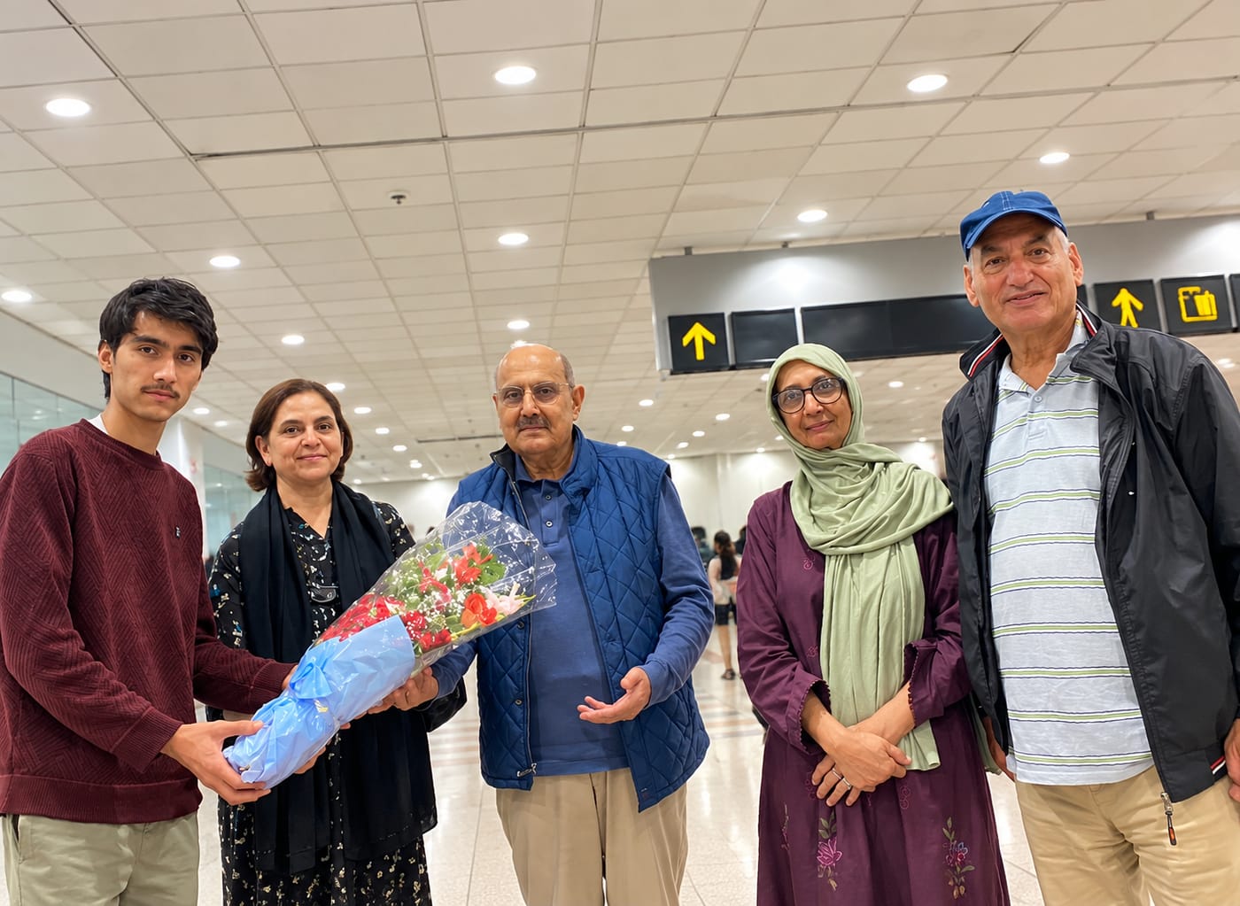 A Pakistan Travellers team member welcoming a family at Islamabad airport with flowers